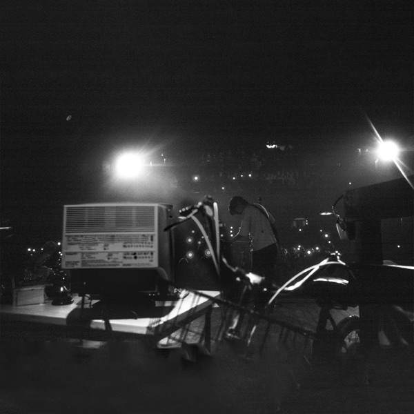 Capa de Internet hometown hero (offline): CRT e bicicleta em primeiro plano, MICO pequeno no palco, em preto e branco