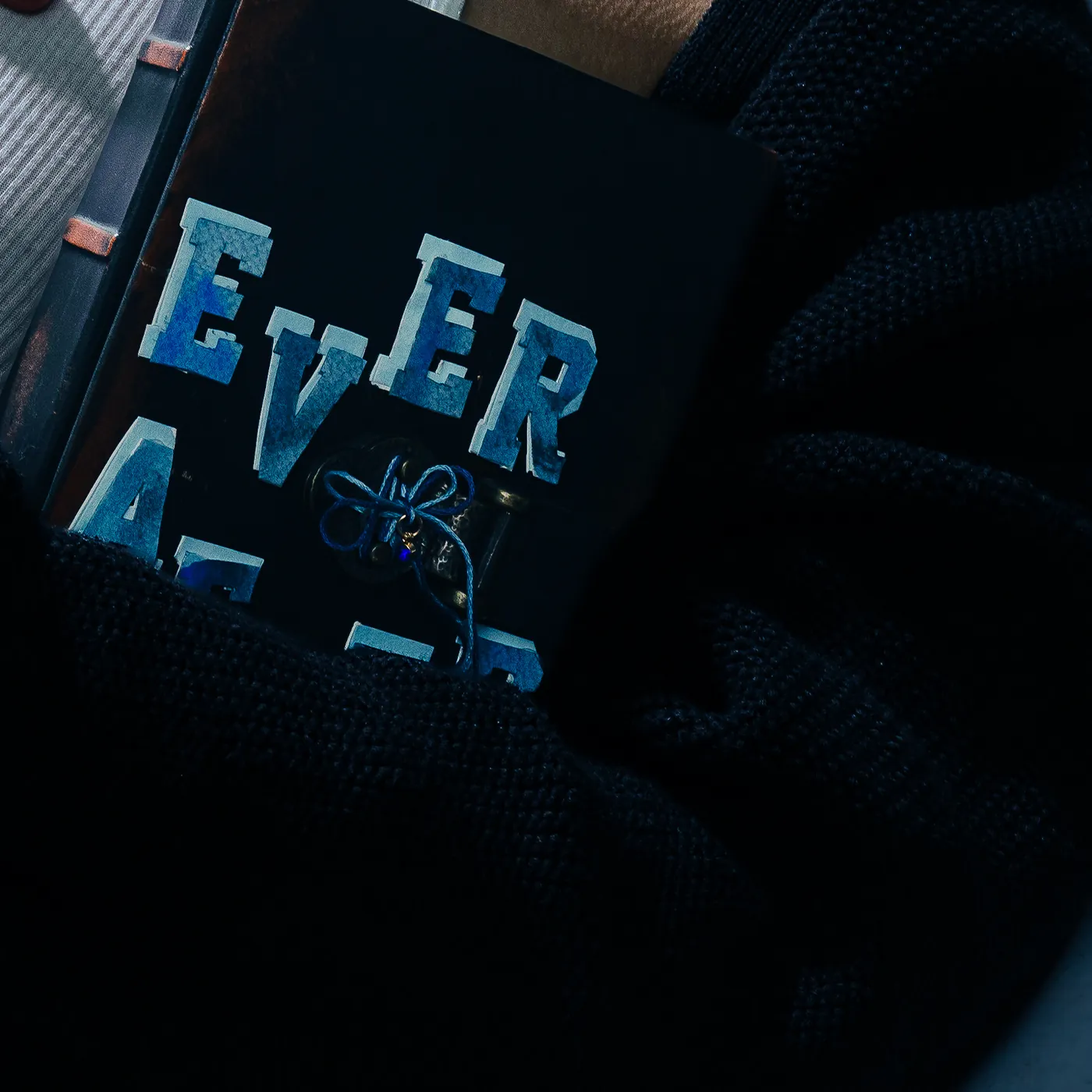 Detalhe do livro EVER AFTER no peito, do photoshoot da capa